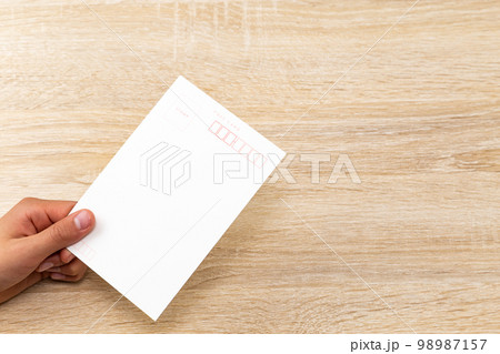ハガキを持つ手元 98987157