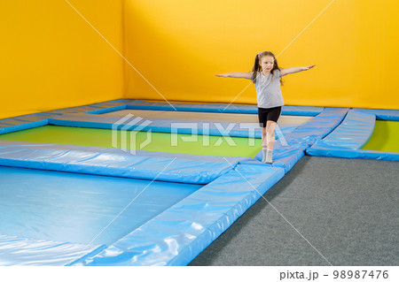 Happy smiling small kids jumping on indoors trampoline in entertainment center 98987476