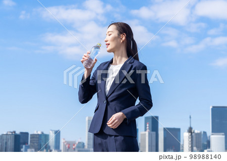 屋外で水分補給をする美容を気遣う若い女性 98988140