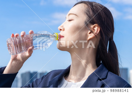 屋外で水分補給をする美容を気遣う若い女性 98988141