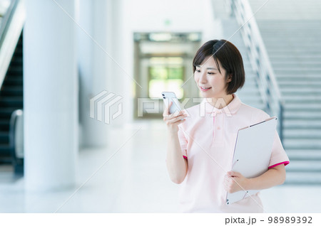 施設で働く若い女性介護士 施設で働く若い女性介護士 98989392