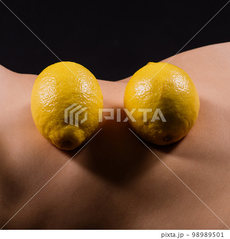 Young woman with cellulite problem and lemon on dark background, closeup 98989501
