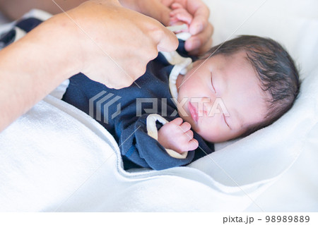 産院で眠っているところパパに肌着を着せられる生まれたての赤ちゃん 98989889