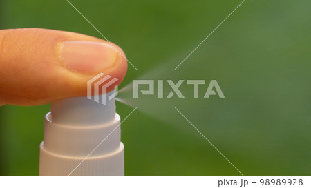 Finger pressing the spray Finger pressing the spray 98989928