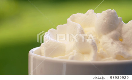 Putting whipping cream into a cup 98989929