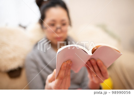 読書をする女性が持っている本 読書をする女性が持っている本 98990056