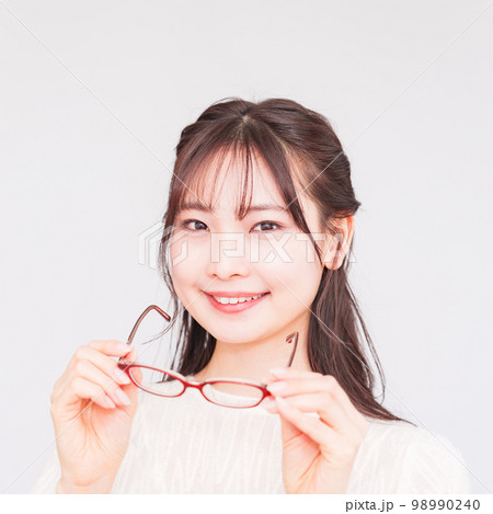 眼科 で 若い 女性 が 視力検査 のために メガネ を外す 【 レーシック の イメージ 】 98990240
