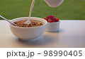Milk pouring into corn flakes 98990405