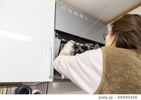 キッチンの換気扇を掃除する女性 98990406