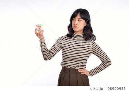 Asian woman holding a rubik cube standing on white background. solving cubic problems, problem solution and making strategic moves concept 98990955