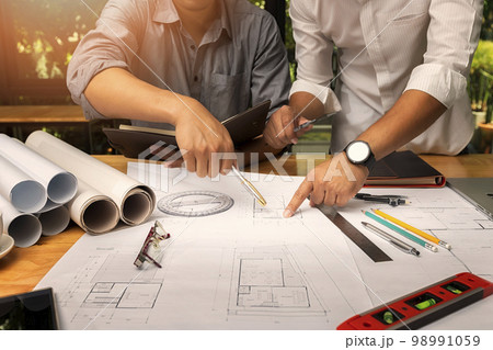 Confident team of architect working together in a office.They discussing about new startup project on desk. Architect discuss with engineer about project in office, architectural concept Confident team of architect working together in a office.They discussing about new startup project on desk. Architect discuss with engineer about project in office, architectural concept 98991059