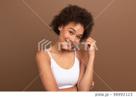 Cheerful pretty young african american curly woman with natural beauty, perfect skin in white top 98992123