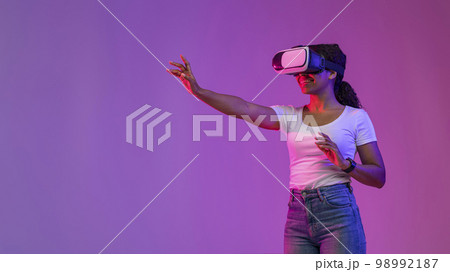 Virtual Experience. Smiling Black Lady Playing Video Game In VR Headset 98992187