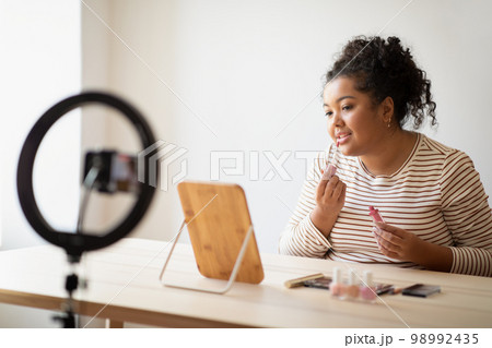 Pretty overweight young lady makeup artist recording video 98992435