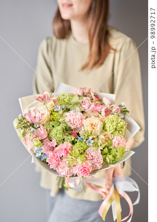 Florist woman creates beautiful bouquet of mixed flowers with varietal carnations, bush veronica, oxypetalum, ranunculus. European floral shop concept. Handsome fresh bunch. Education, master class Florist woman creates beautiful bouquet of mixed flowers with varietal carnations, bush veronica, oxypetalum, ranunculus. European floral shop concept. Handsome fresh bunch. Education, master class 98992717