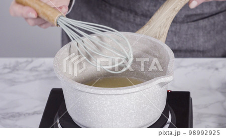 Step by step. Cooking cake syrup for cake in a saucepan. Step by step. Cooking cake syrup for cake in a saucepan. 98992925