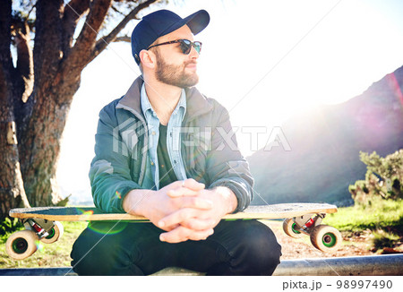 Skateboard, sports and man thinking on mountain for adventure, freedom and ready for skateboarding. Urban fashion, fitness and profile of skater with board for exercise, skating and training outdoors 98997490