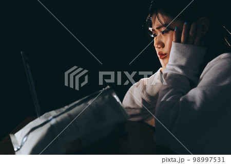夜中に不摂生な生活をする若い女性の写真 98997531