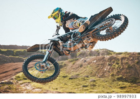 Motorcross, air jump and offroad sports stunt, speed challenge and desert rally. Driver, cycling and freedom on dirt race, competition and motorbike performance on adventure course for fast action Motorcross, air jump and offroad sports stunt, speed challenge and desert rally. Driver, cycling and freedom on dirt race, competition and motorbike performance on adventure course for fast action 98997933