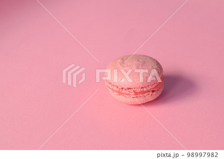 A pink macaroon on a minimalistic pink background 98997982