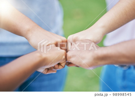 People, hands and fist bump in collaboration for community, partnership or trust together in the outdoors. Hand of team bumping fists in unity for agreement, coordination or support in solidarity 98998545