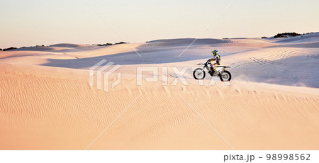 Desert, nature and athlete riding a motorcycle for exercise, fitness or skill training in nature. Extreme sports, action and male athlete on a bike for an outdoor workout in the sand dunes in Dubai. Desert, nature and athlete riding a motorcycle for exercise, fitness or skill training in nature. Extreme sports, action and male athlete on a bike for an outdoor workout in the sand dunes in Dubai. 98998562