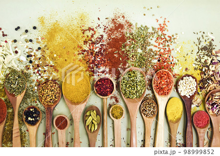 Colorful mix of herb and spice varieties: curry and coriander, turmeric and cumin, paprika and pepper, mustard and salt, cardamon and oregano and saffron. Food ingridients background Colorful mix of herb and spice varieties: curry and coriander, turmeric and cumin, paprika and pepper, mustard and salt, cardamon and oregano and saffron. Food ingridients background 98999852