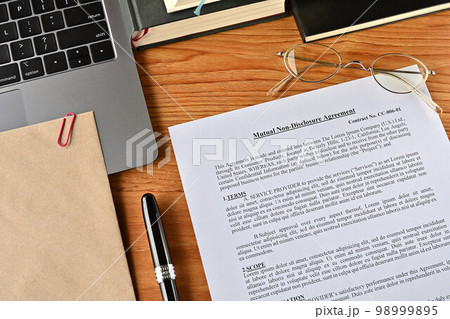 デスクにペンやノートとともに、ダミーの英語の相互秘密保持契約が置かれている 98999895