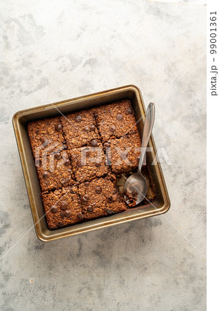 top view, vegan brownies with chocolate chips and rolled oats in square baking tray. 99001361