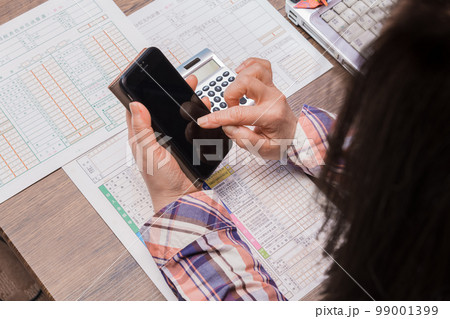 【確定申告の計算をする主婦】 【確定申告の計算をする主婦】 99001399