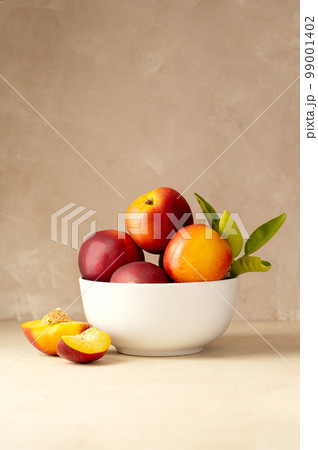 Nectarine peaches fruits in a bowl. Neutral background. Nectarine peaches fruits in a bowl. Neutral background. 99001402