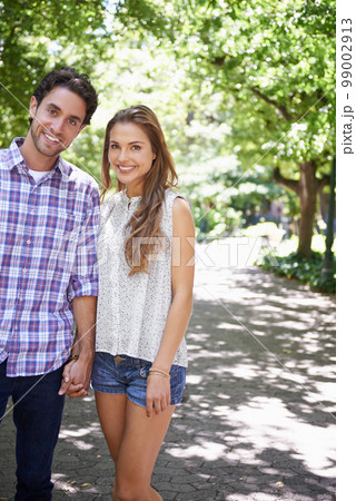 Bonding couple, portrait or holding hands in park, nature or garden walk on valentines day date, romance love or summer break. Smile, happy man or woman in relax trust, partnership or safety support 99002913
