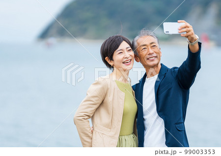スマホで自撮りするシニアカップル 99003353