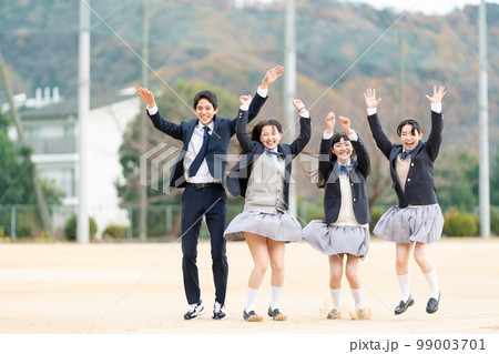 校庭でジャンプする女子高生と男子学生 99003701