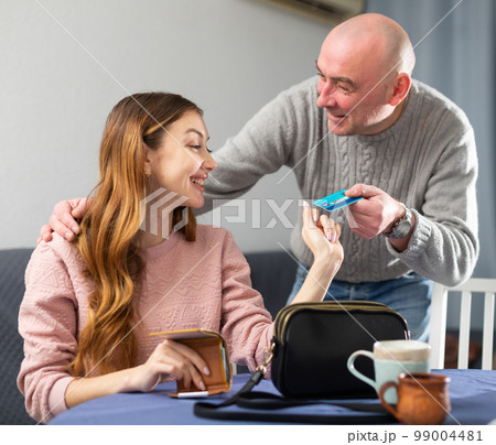 Husband giving plastic card to his wife Husband giving plastic card to his wife 99004481