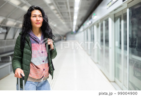 Woman going along just arrived train in subway station Woman going along just arrived train in subway station 99004900