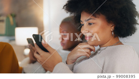 Social media phone, home relax and friends in communication on mobile app, search the internet and smile for notification. African women on the living room sofa with mobile internet connection Social media phone, home relax and friends in communication on mobile app, search the internet and smile for notification. African women on the living room sofa with mobile internet connection 99008395