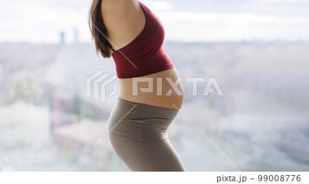Pregnant woman belly in profile. Healthy pregnancy concept image of beautiful expectant mother showing baby bump in closeup Pregnant woman belly in profile. Healthy pregnancy concept image of beautiful expectant mother showing baby bump in closeup 99008776