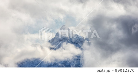 Mountains covered in Snow and Clouds during Winter Season. Mountains covered in Snow and Clouds during Winter Season. 99012370