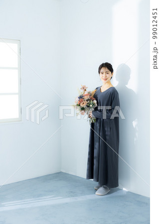 花束を持つグレーのワンピースの女性　 99012451