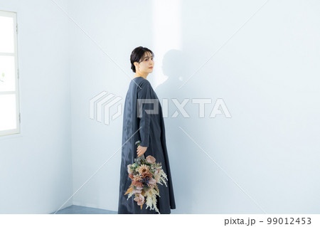 花束を持つグレーのワンピースの女性　 99012453
