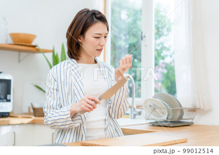 指を切る女性　キッチン　包丁 99012514