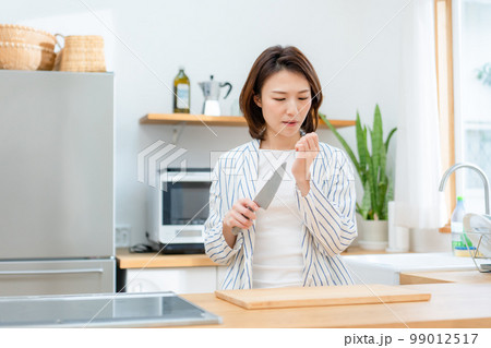 指を切る女性　キッチン　包丁 99012517