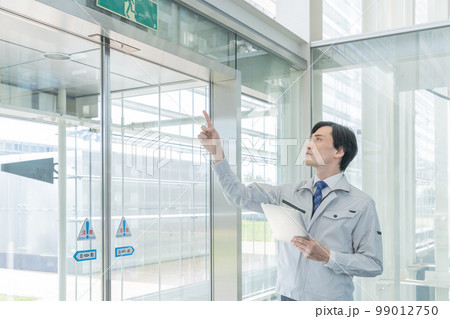 ビルの点検をする作業服の男性 99012750