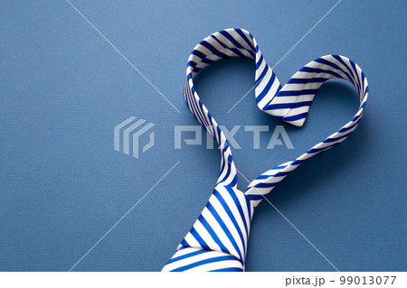 Tie in heart shape on blue background with copy space Tie in heart shape on blue background with copy space 99013077
