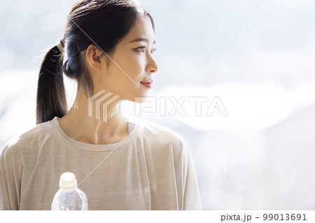フィットネスジムで水分補給をする若い女性 休憩 フィットネスジムで水分補給をする若い女性 休憩 99013691