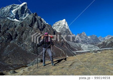 Hiker woman posing with mountains at background Hiker woman posing with mountains at background 99014658
