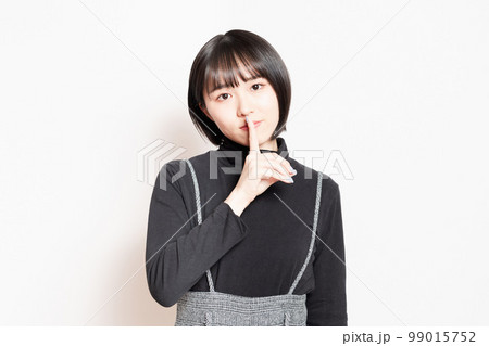 口を手で隠している若い女性 99015752