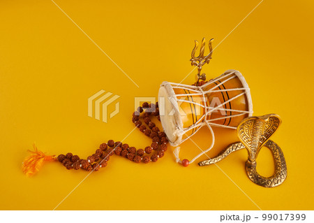 Shivaratri background with Shivas trident, Pellet Drum Damroo musical instrument ans snake . Maha Shivratri festval 99017399