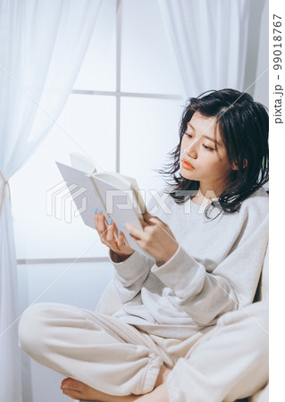 ソファーに寝転がる若い女性の写真 ソファーに寝転がる若い女性の写真 99018767